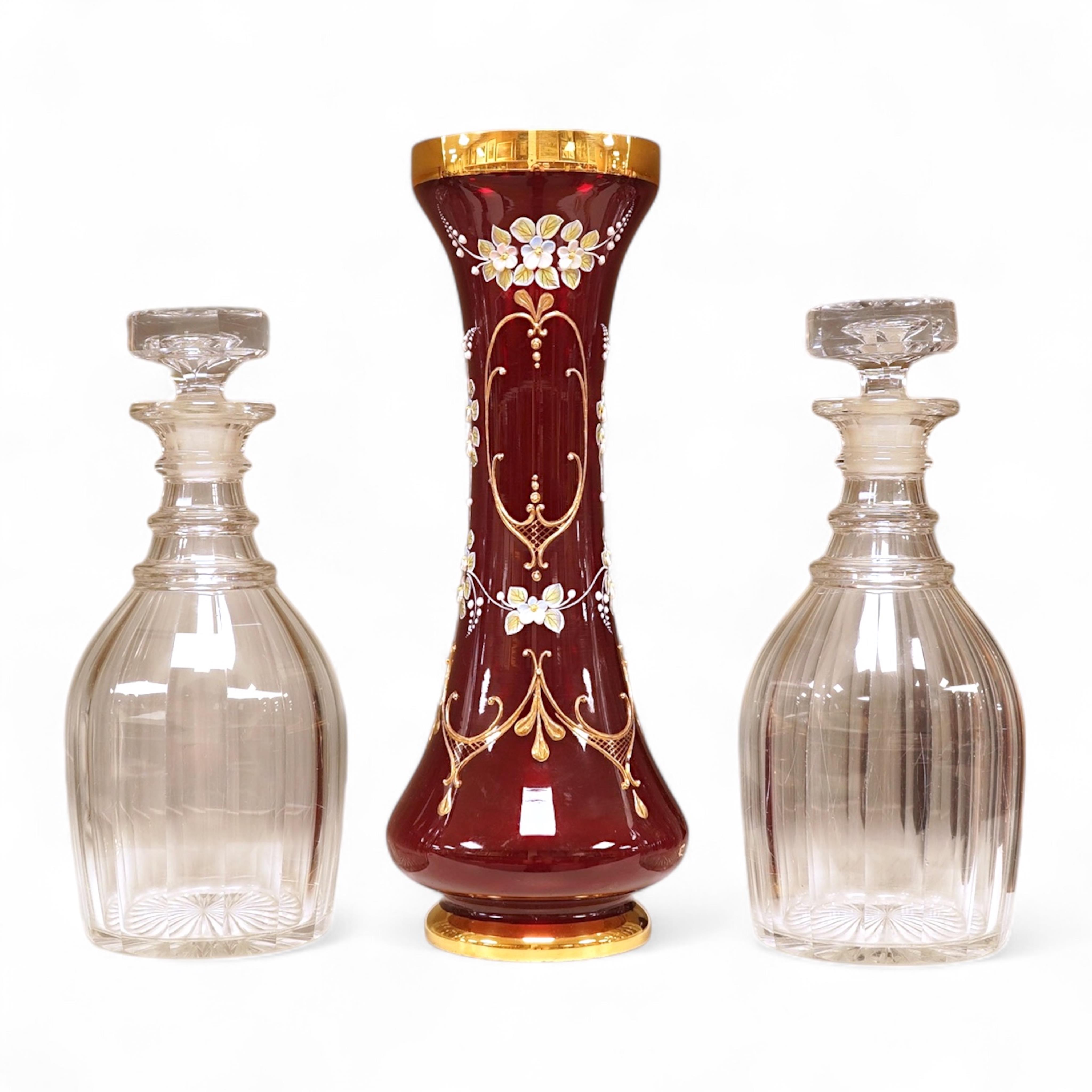 A pair of Victorian glass decanters, later stoppers, and an enamelled ruby glass vase, latter 32cm high